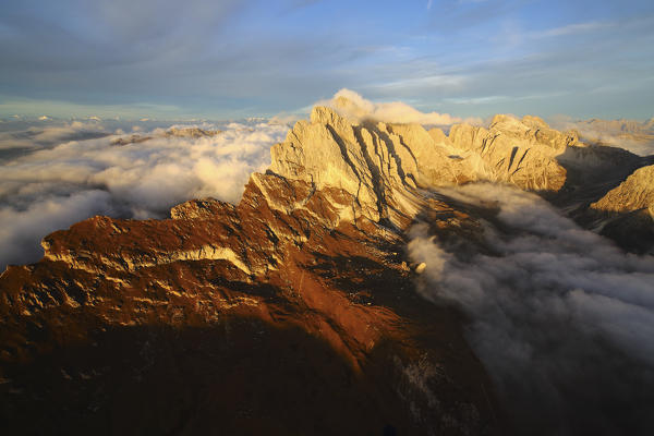 Aerial shot from Seceda of Odle surrounded by clouds at sunset. Dolomites Val Funes Trentino Alto Adige South Tyrol Italy Europe