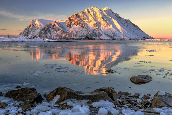 View of the mountains of Gymsøya from Smorten reflected in the clear sea. Lofoten Islands Norway Europe