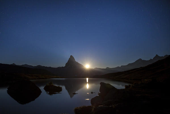 The Matterhorn is reflected in Stellisee in a full moon night. Zermatt Canton of Valais Pennine Alps Switzerland Europe