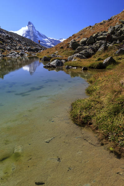 Hiker admire the Matterhorn at sunrise. Zermatt Canton of Valais Pennine Alps Switzerland Europe