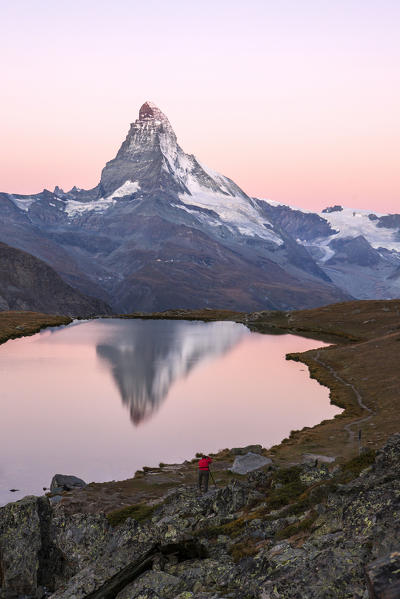 The photographer captures the Matterhorn under a pink sky at dawn from Stellisee. Zermatt Canton of Valais Pennine Alps Switzerland Europe