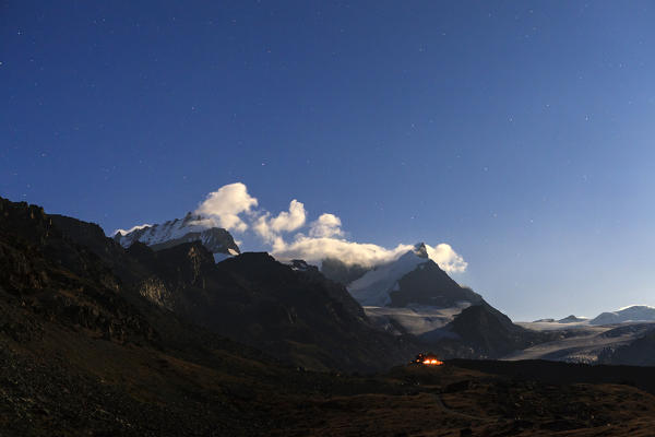 The lights of the Alben refuge seen from Stellisse in a full moon night. Zermatt Canton of Valais Pennine Alps Switzerland Europe