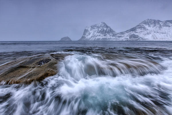 Waves crashing on the rocks of the cold sea. Haukland. Lofoten Islands Northern Norway Europe