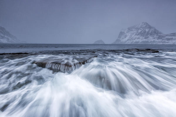 Waves crashing on the rocks of the cold sea. Haukland. Lofoten Islands Northern Norway Europe