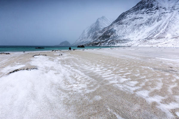 Beach partially snowy surrounded by mountains. Haukland. Lofoten Islands Norway Northern Europe