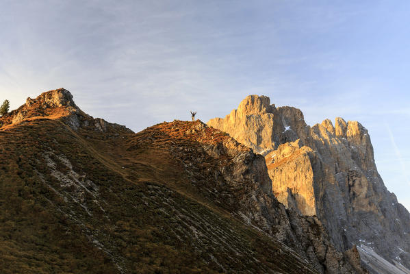 Hiker on the peaks of Forcella De Furcia at sunrise. Funes Valley South Tyrol Dolomites Italy Europe