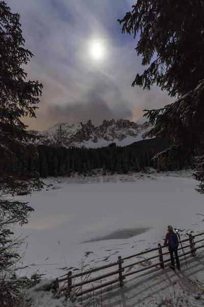 Full moon at Lake Carezza in the background the Latemar group. Ega Valley. Dolomites. Trentino Alto Adige Italy