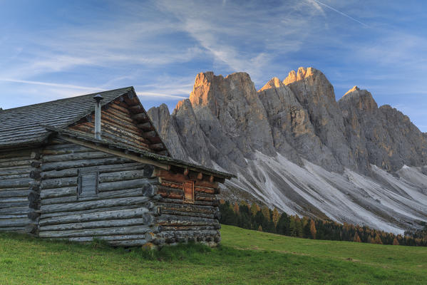 The early morning light illuminates Malga Gampen and the Odle in background. Funes Valley South Tyrol Dolomites Italy Europe