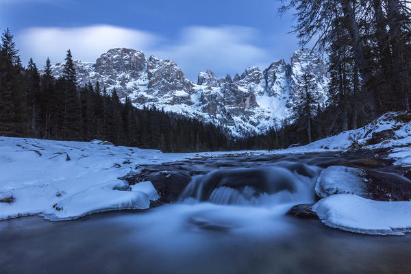 A frozen creek under a cold winter sky. Venagia Valley Panaveggio Natural Park Dolomites Trentino Alto Adige Italy Europe