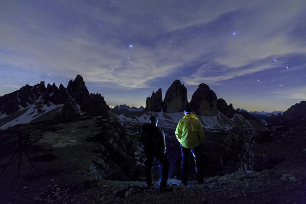 Hikers admire the Three Peaks of Lavaredo at night. Sesto Dolomites Trentino Alto Adige Italy Europe