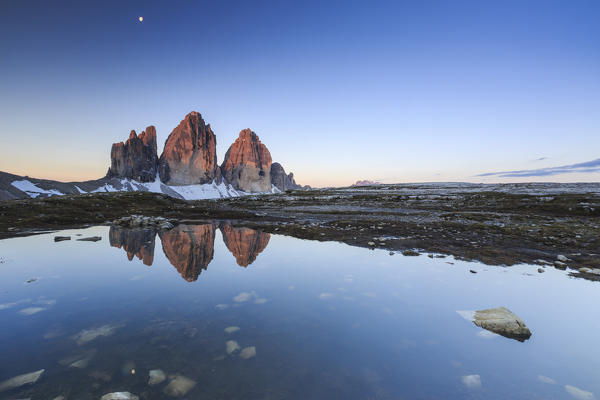 Dawn illuminates the Three Peaks of Lavaredo reflected in the lake. Sesto Dolomites Trentino Alto Adige Italy Europe