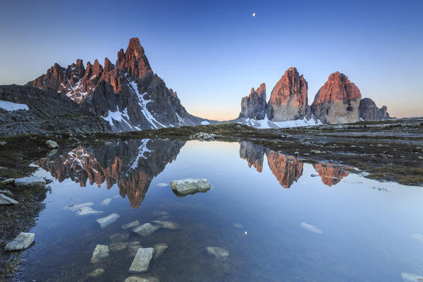 Dawn illuminates the Three Peaks and Mount Paterno reflected in the lake. Sesto Dolomites Trentino Alto Adige Italy Europe