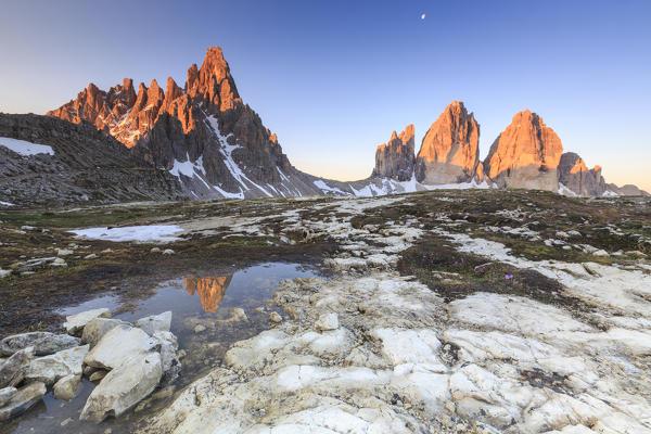 Dawn illuminates the Three Peaks and Mount Paterno reflected in the lake. Sesto Dolomites Trentino Alto Adige Italy Europe