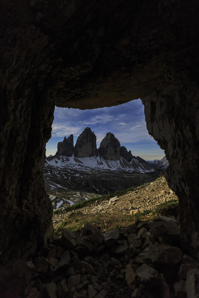 The Three Peaks of Lavaredo seen from a cave at night. Sesto Dolomites Trentino Alto Adige Italy Europe