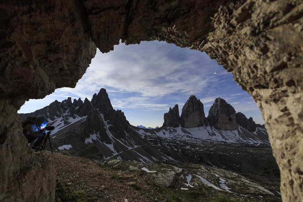 The Three Peaks of Lavaredo seen from a cave at night. Sesto Dolomites Trentino Alto Adige Italy Europe