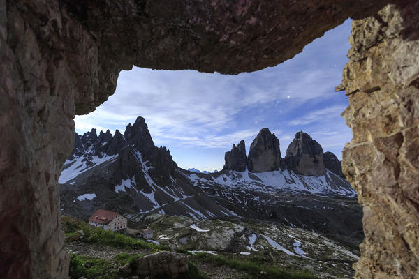 The Three Peaks of Lavaredo seen from a cave at night. Sesto Dolomites Trentino Alto Adige Italy Europe