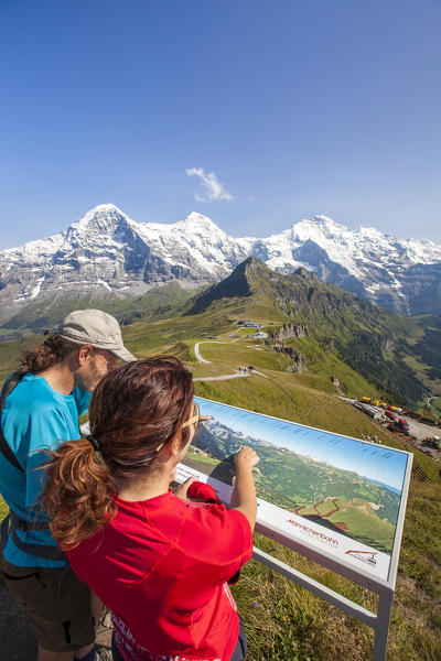 Hikers look on the map before proceed Mannlichen Grindelwald Bernese Oberland Canton of Berne Switzerland Europe