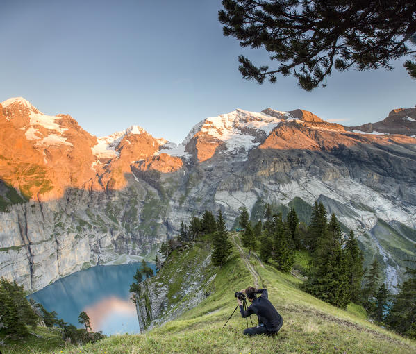 Photographer in action at Lake Oeschinensee Bernese Oberland Kandersteg Canton of Bern Switzerland Europe