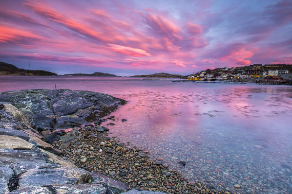 Pink sky at sunrise reflected in the cold waters Flatanger Trøndelag Norway Europe