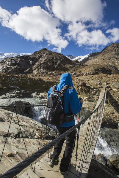 Hiker on Tibetan bridge Cedec Valley Valfurva Valtellina Lombardy Italy Europe