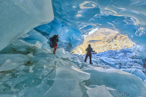 Hikers inside Forni Glacier Forni Valley Stelvio National Park Valfurva Valtellina Lombardy Italy Europe