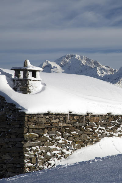 Snow covered hut after a heavy snowfall in the background Mount Disgrazia Olano Valtellina Rhaetian Alps Lombardy Italy Europe