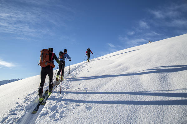 Alpine skiers through the snowy landscape Gerola Valley Valtellina Orobie Alps Lombardy Italy Europe