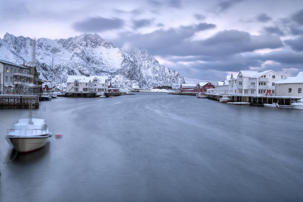 The typical fishing village of Henningsvaer surrounded by snow capped mountains and the cold sea Lofoten Islands Northern Norway Europe