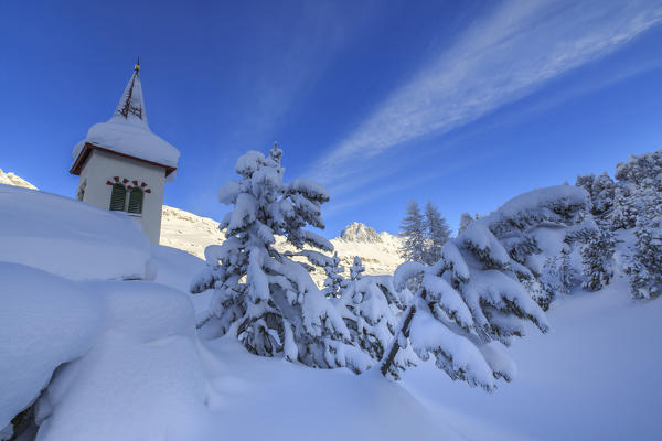 The bell tower submerged by snow surrounded by woods Maloja Canton of Graubünden Engadine Switzerland Europe