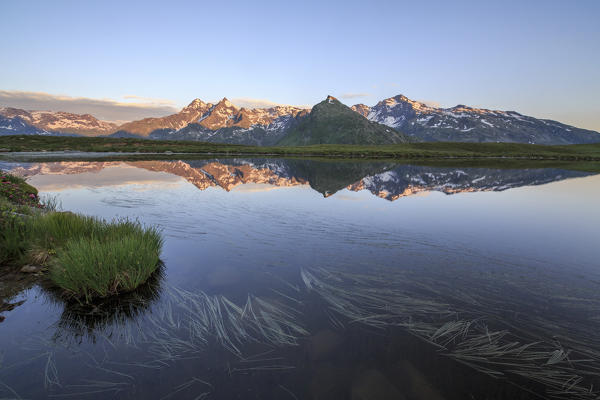 Mount Cardine and Peak Tambò are reflected in Lake Andossi at sunrise Chiavenna Valley Valtellina Lombardy Italy Europe