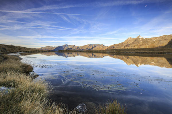 Mount Cardine and Peak Tambò are reflected in Lake Andossi at sunrise Chiavenna Valley Valtellina Lombardy Italy Europe