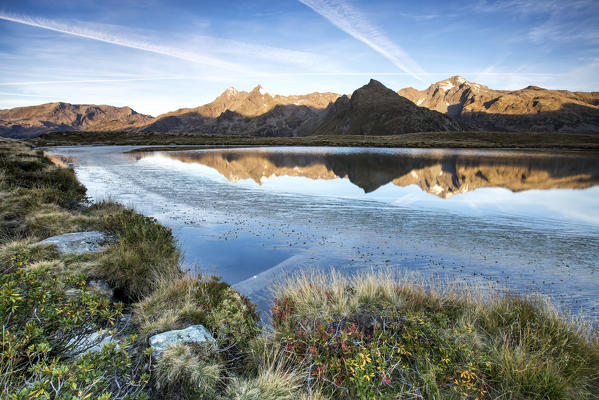 Peaks Tambò and Piani are reflected in Lake Andossi at sunrise Chiavenna Valley Valtellina Lombardy Italy Europe