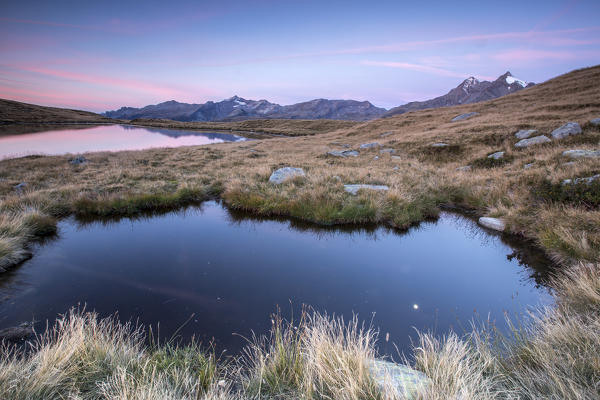 Pink sky at sunrise on Lake Andossi Chiavenna Valley Spluga Valley Valtellina Lombardy Italy Europe