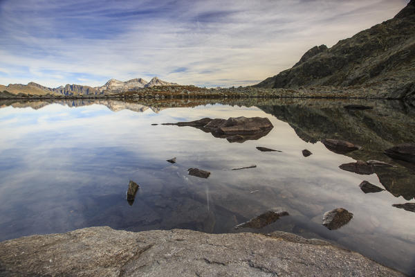 Peaks are reflected in Lake Bergsee at dawn Chiavenna Valley Spluga Valley Switzerland Europe