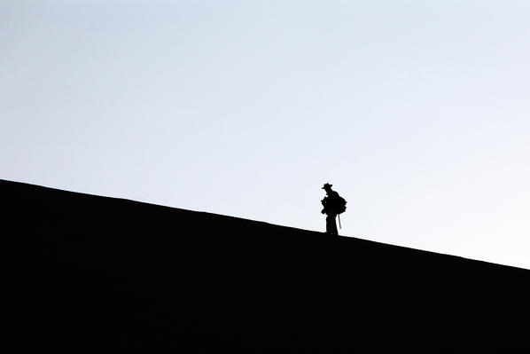 Profile of a hiker on the sand dune shaped by the wind Deadvlei Sossusvlei Namib Desert Naukluft National Park Namibia Africa