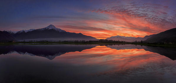 Panoramic view of Pian di Spagna flooded with snowy peaks reflected in the water at sunset Valtellina Lombardy Italy Europe