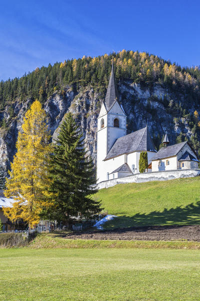 The church of Schmitten surrounded by colorful woods Albula District Canton of Graubünden Switzerland Europe