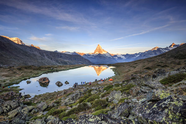 Hikers admire Matterhorn reflected in Lake Stellisee at dawn Zermatt Canton of Valais Switzerland Europe