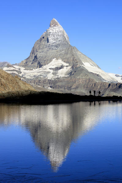 Hikers admire the Matterhorn reflected in Lake Stellisee Zermatt Canton of Valais Pennine Alps Switzerland Europe