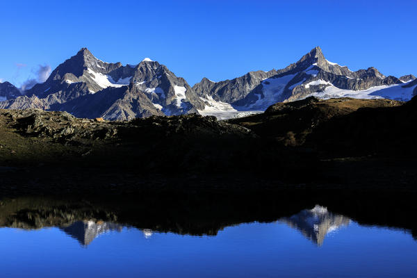 View of OberGabelhorn and Zinalrothorn reflected in the blue waters Zermatt Canton of Valais Switzerland Europe