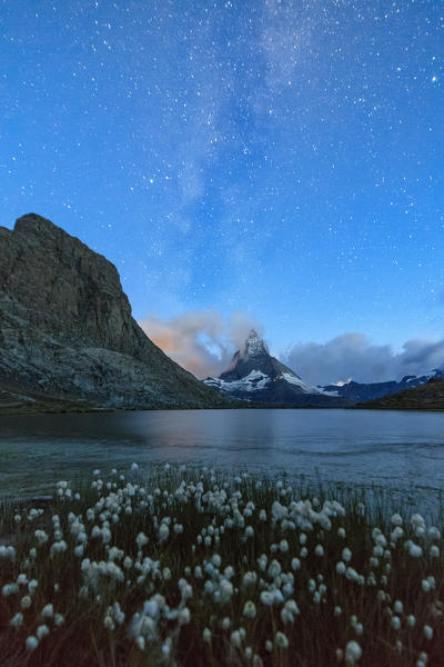 Stars and Milky Way above Lake Stellisee surrounded by cotton grass Zermatt Canton of Valais Switzerland Europe