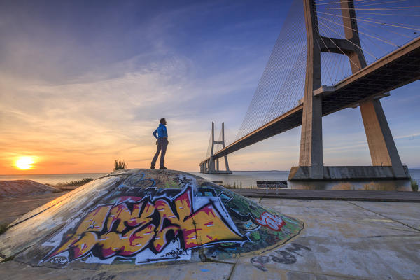 A tourist admires the majestic Vasco da Gama Bridge over the River Tagus Parque das Nações Lisbon Portugal Europe