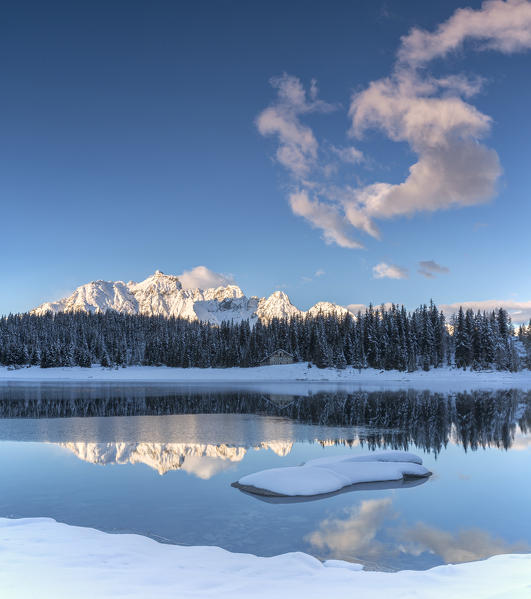 Woods and snowy peaks are reflected in the clear water of Palù Lake Malenco Valley Valtellina Lombardy Italy Europe