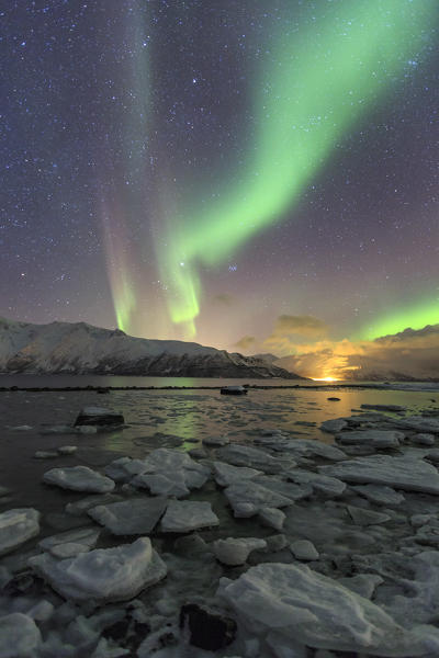 The Northern Lights illuminates the icy landscape in Svensby Lyngen Alps Tromsø Lapland Norway Europe