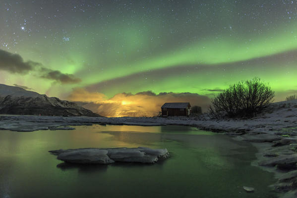 The Northern Lights illuminates the icy landscape in Svensby Lyngen Alps Tromsø Lapland Norway Europe