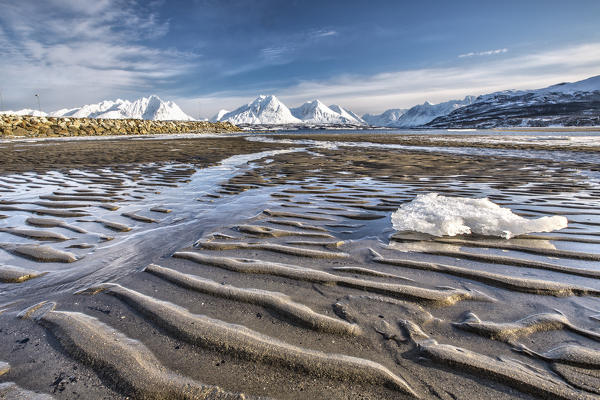 The icy sandy beach surrounding the snow capped mountains Breivikeidet Lyngen Alps Tromsø Lapland Norway Europe