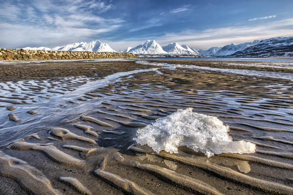 The icy sandy beach surrounding the snow capped mountains Breivikeidet Lyngen Alps Tromsø Lapland Norway Europe