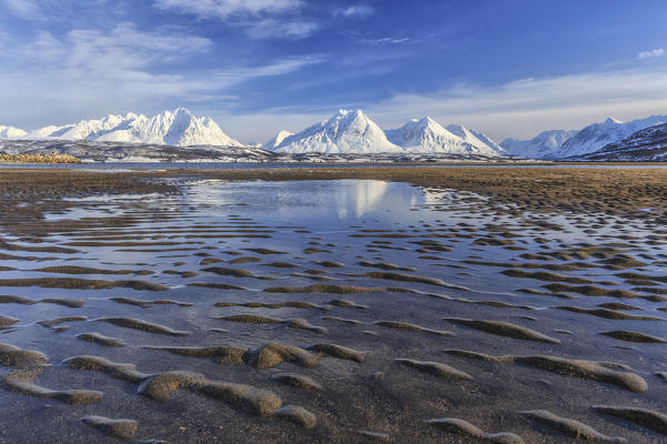 The icy sandy beach surrounding the snow capped mountains Breivikeidet Lyngen Alps Tromsø Lapland Norway Europe