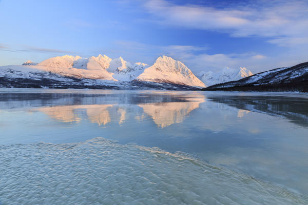 Blue sky and snowy peaks are reflected in the frozen Lake Jaegervatnet Stortind
Lyngen Alps Tromsø Lapland Norway Europe