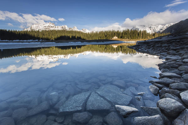 The spring thaw melts ice while snowy peaks are reflected in Lake Palù Sondrio Malenco Valley Valtellina Lombardy Italy Europe